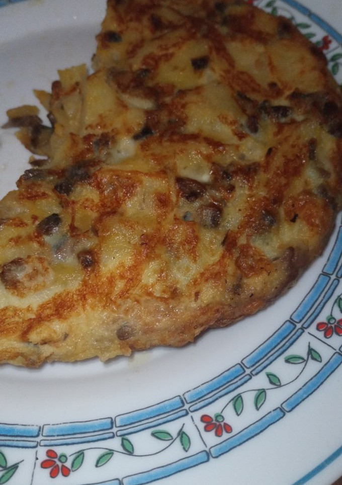 Una foto de Tortilla de patatas cebolla y champiñones