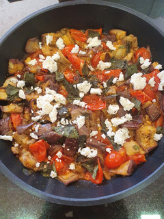 Una foto de Berenjena y tomates cherry con albahaca y queso feta