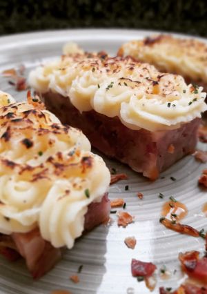 Una foto de Lingote de pies de cerdo con cebolla caramelizada y puré