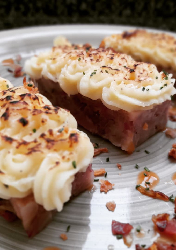 Una foto de Lingote de pies de cerdo con cebolla caramelizada y puré