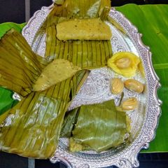A picture of Steamed jackfruit cake wrapped in banana leaves.