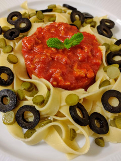Una foto de Tagliatelles salteados con encurtidos y pesto rosso con nueces