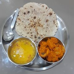 A picture of Arbi Masala Fry with jowar roti and dal.