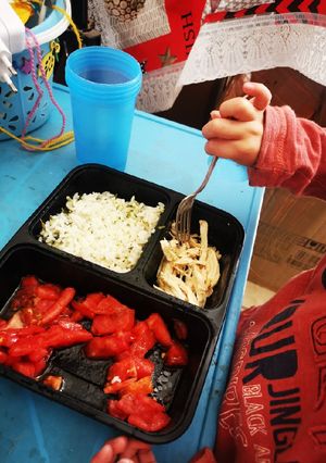 Una foto de Pollo con arroz y ensalada de tomate