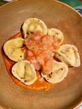 Tortelli fatti in casa ripieni di ricotta e scorza di limone con datterini, zenzero e gamberi rossi