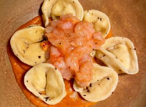 Foto di Tortelli fatti in casa ripieni di ricotta e scorza di limone con datterini, zenzero e gamberi rossi