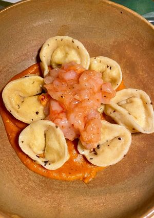 Foto di Tortelli fatti in casa ripieni di ricotta e scorza di limone con datterini, zenzero e gamberi rossi
