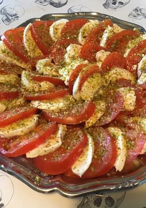 Une photo de Salade de tomates à la mozzarella di buffala et pistaches