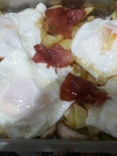 Una foto de Huevos fritos con patatas y jamón serrano