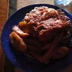 A picture of Beans with fried plantain and sauce.