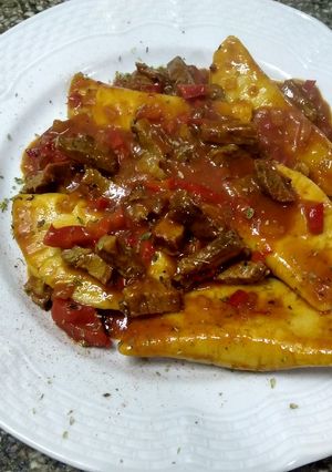 Una foto de Pierogi relleno con calabaza y muzzarella y tuco con tapa de asado