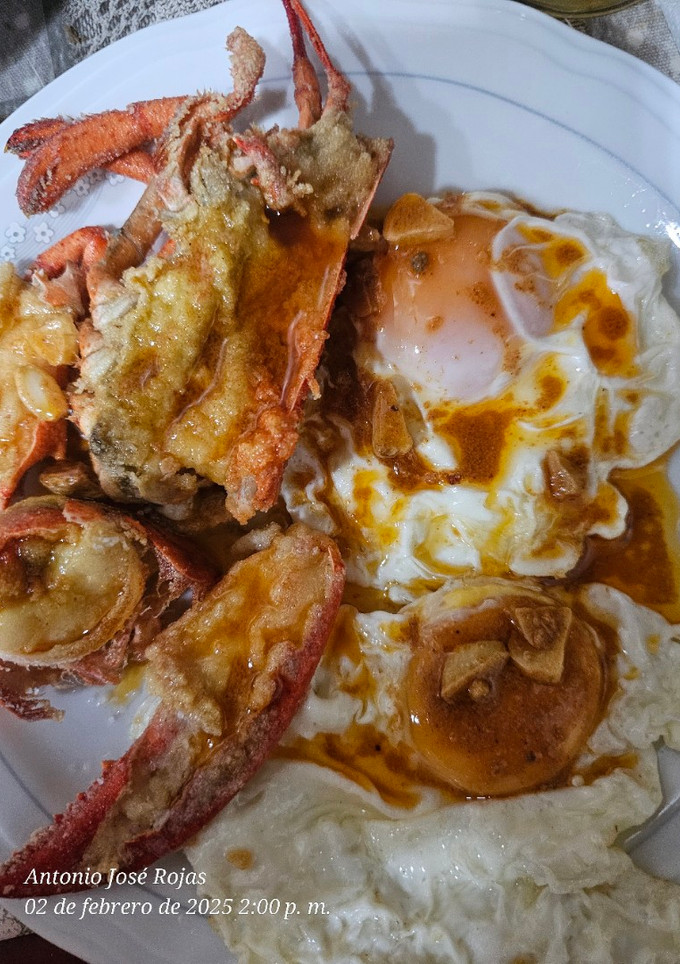 Una foto de Huevos fritos y bogavante frito con vinagreta de jugo de bogavante