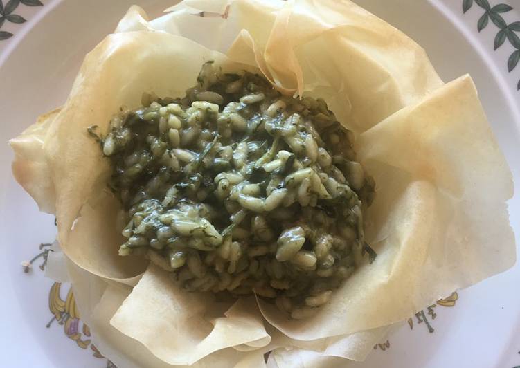 Risotto con erbe di campo servito su ciotola di pasta fillo