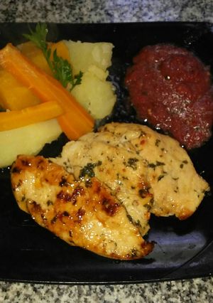 Una foto de Pollo con hierbas verduras y tomate fresco con albahaca