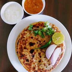 A picture of Dhaba style aloo paratha with mango garlic chutney.