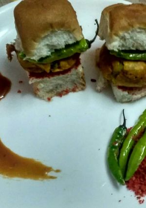 A picture of Authentic vada pav with traditional spicy chutney & fried chilli.
