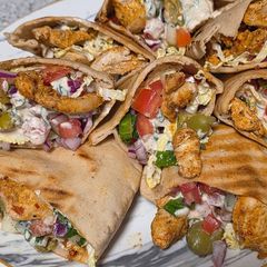 A picture of Chicken gyros in pita pockets.