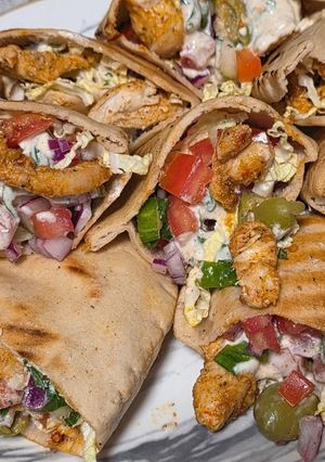 A picture of Chicken gyros in pita pockets.