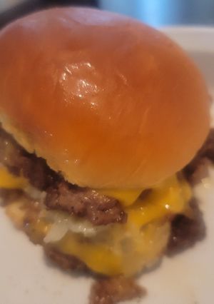 A picture of Smothered and Covered Smash Burgers on Hawaiian Buns.