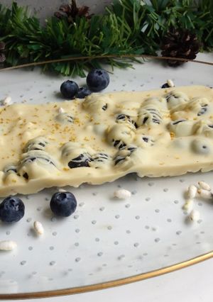 Una foto de Turrón de chocolate blanco, arroz inflado, arándanos y limón