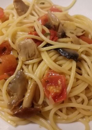 A picture of Spaghetti with mushrooms and fresh tomatoes.