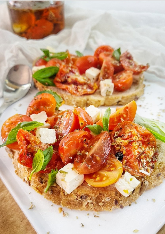 Una foto de Tostas de tomates, queso feta y albahaca