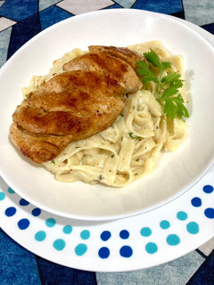 A picture of Grilled chicken in apricot oil with Alfredo Fettuccine.