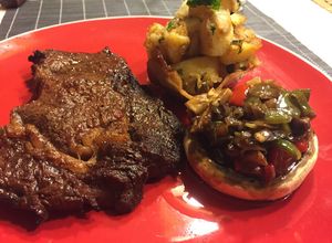 Una foto de *Canasto de papas salteadas, champiñón relleno, lomo a la parrilla*