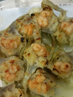 Una foto de Alcachofas con cebolla caramelizada y gambas