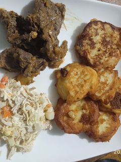 Una foto de Carne sofrito con arepitas de papas y ensalada de pollo navideña