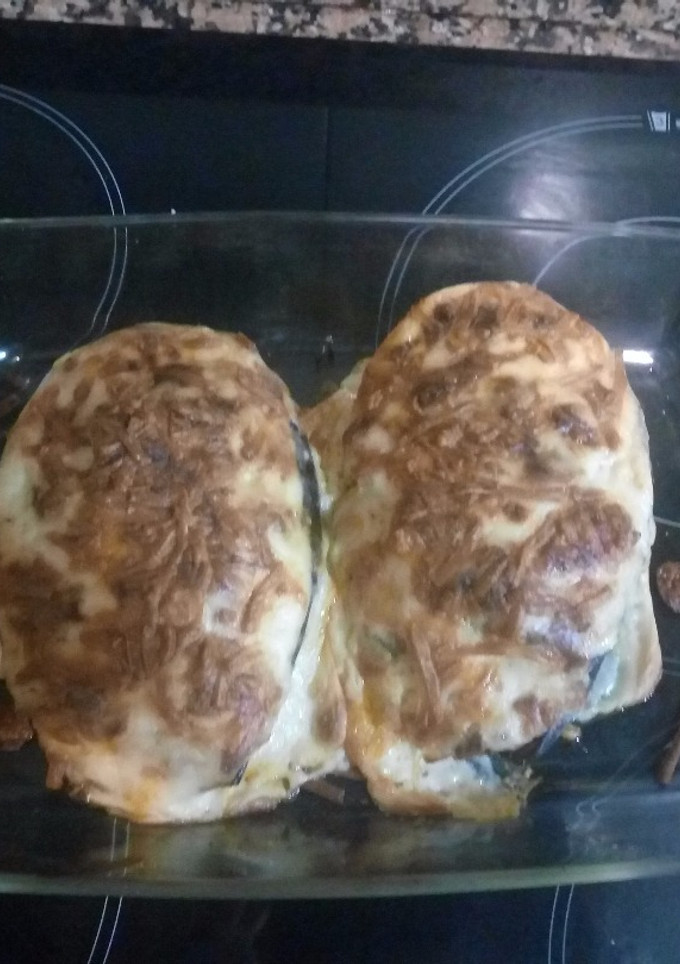 Una foto de Berenjena rellena de carne, virutas de jamón y queso