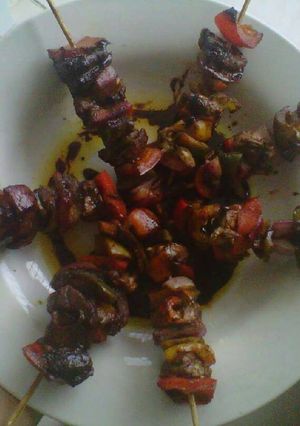 Una foto de brochetas de pollo y vegetales en salsa de mango.