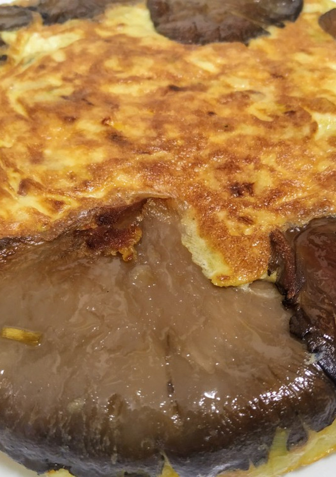 Una foto de Tortilla de patata, calabacín y puerro, abrazada por setas