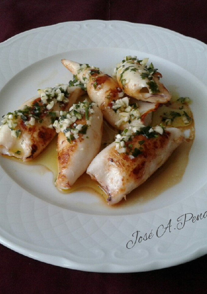 Una foto de Chipirones a la plancha, con picada de ajo y perejil