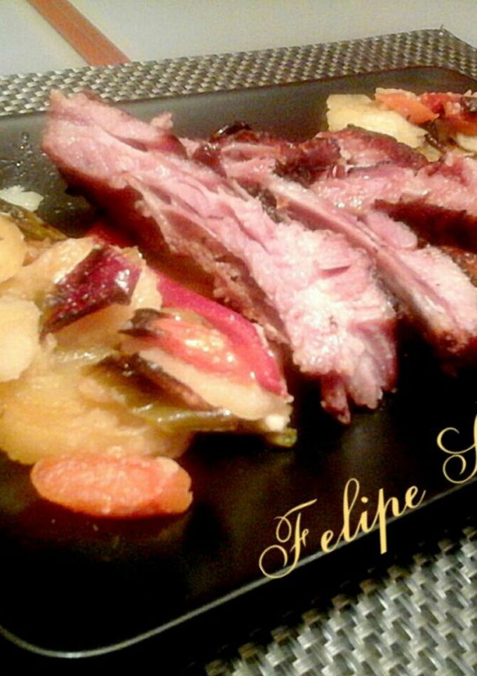 Una foto de Costillas de cerdo ibérico al horno con patatas y verduras asadas