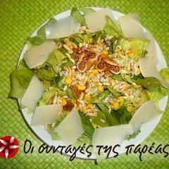 A picture of Salad with lettuce, arugula, figs and pine nuts.