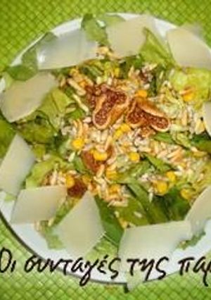 A picture of Salad with lettuce, arugula, figs and pine nuts.