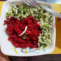 A picture of Beetroot pasta topped with scrambled paneer.