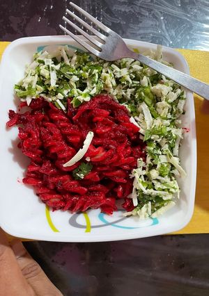 A picture of Beetroot pasta topped with scrambled paneer.