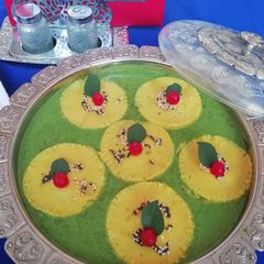 A picture of Khandvi ravioli in spinach curry.