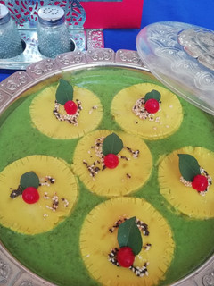A picture of Khandvi ravioli in spinach curry.