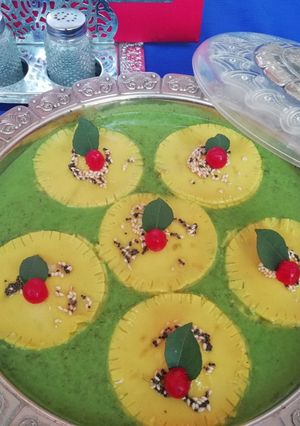 A picture of Khandvi ravioli in spinach curry.