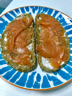 Una foto de Una rebanada de pan con "all i oli"y salmón