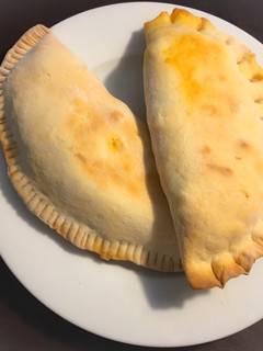 Una foto de Calzone relleno de carne, salchichas y Mozzarella