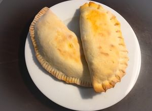 Una foto de Calzone relleno de carne, salchichas y Mozzarella