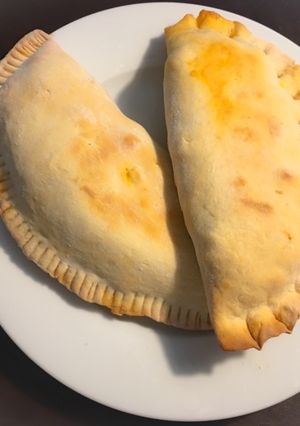 Una foto de Calzone relleno de carne, salchichas y Mozzarella
