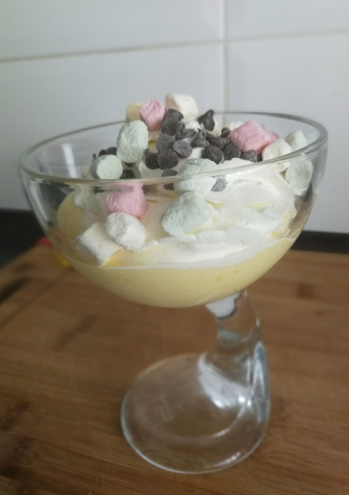 Una foto de Espuma de Mango con nata, nubes y chocolate