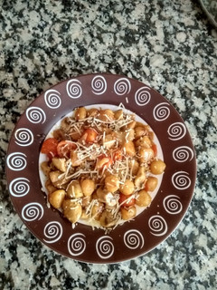 Una foto de Ñoquis con champiñones y tomates cherry