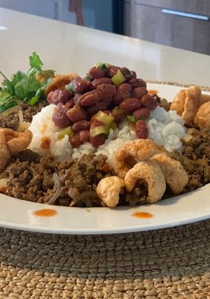 Una foto de Timbal de Arroz, Frijol & Carne Molida Con Florecitas de Chicharrón