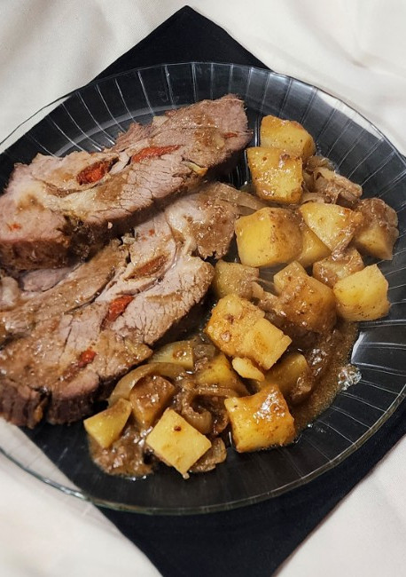 Una foto de 🥩🍖Roast Beef al horno mechado con morrones y ajos sobre colchón de papas y cebollas 🍖🥩